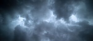 Dramatic dark storm clouds with bright white light breaking through, depicting severe weather conditions typical of hurricane season.